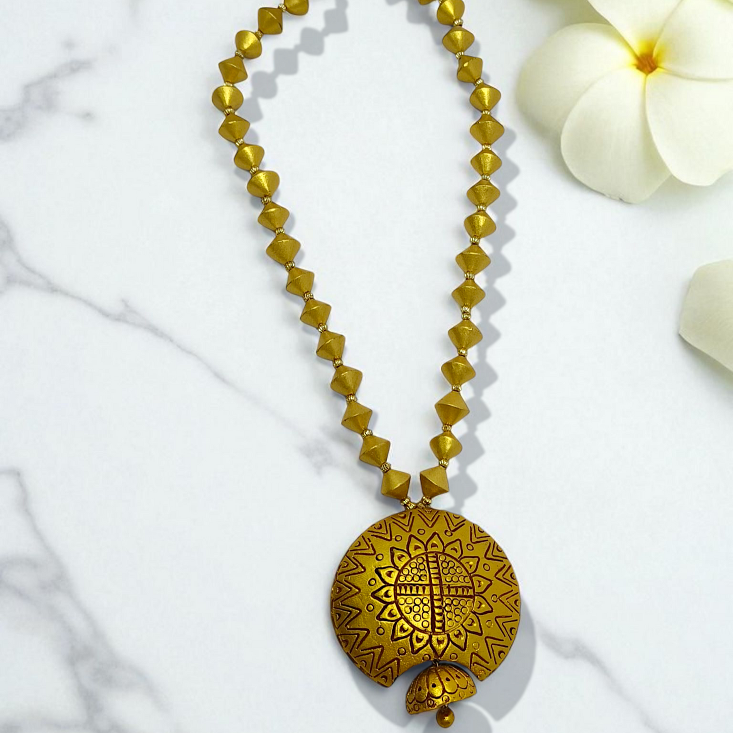Bishnupur Handpainted Terracotta Necklace Set with geometric bead design and floral pendant on marble background