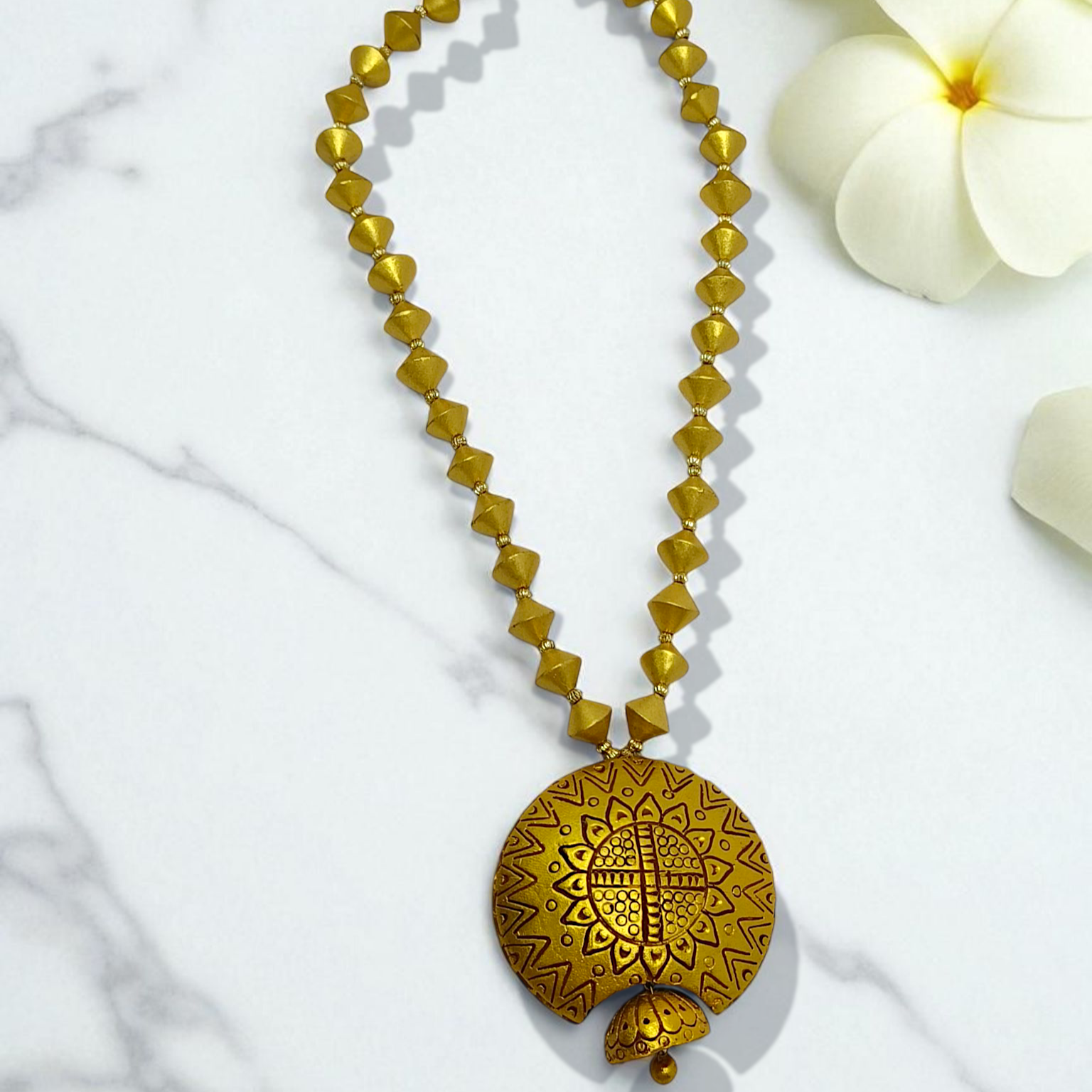 Bishnupur Handpainted Terracotta Necklace Set with geometric bead design and floral pendant on marble background