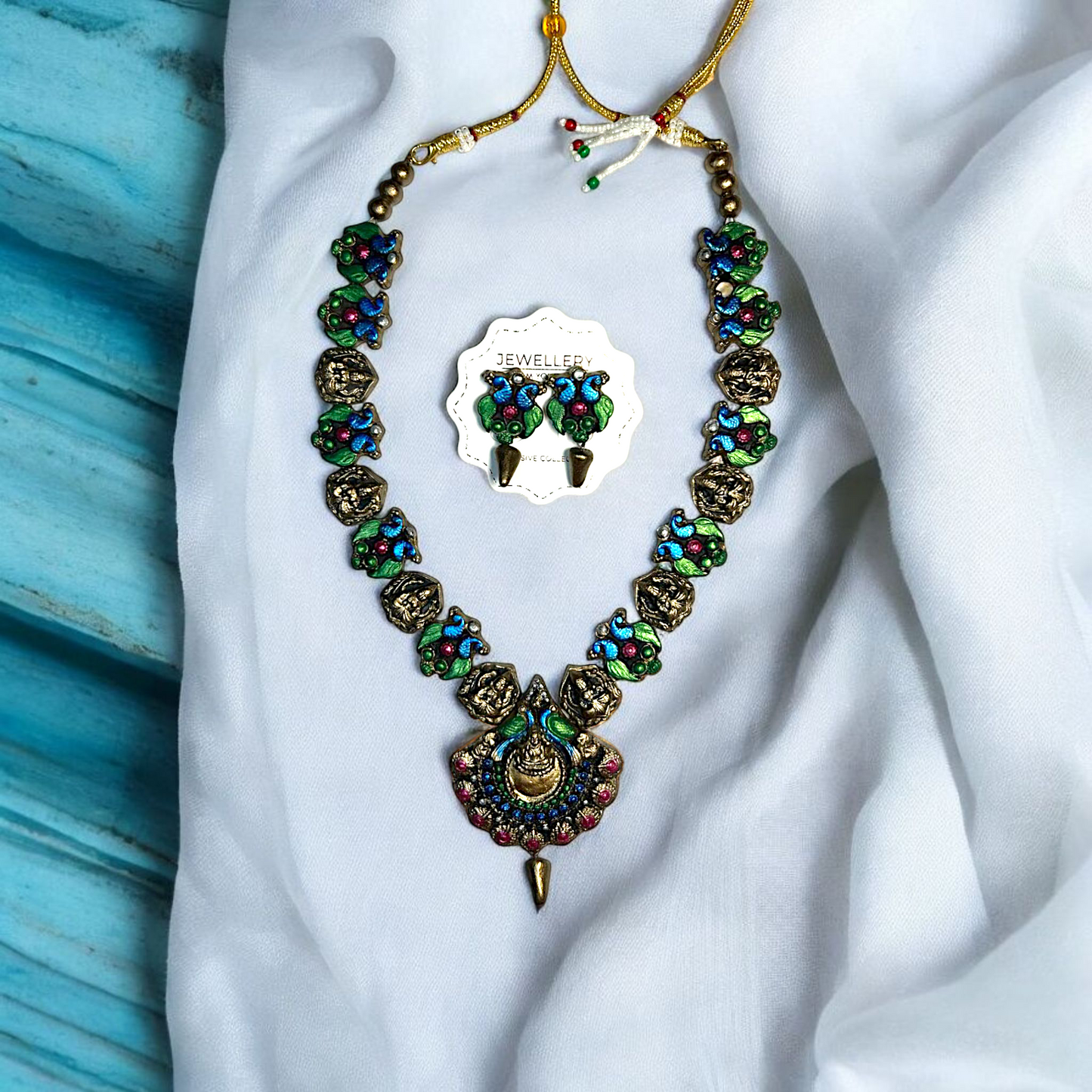 Handmade Artisan Peacock Charm Necklace and Earring Jewelry with colorful blue green and pink details from Mrritika