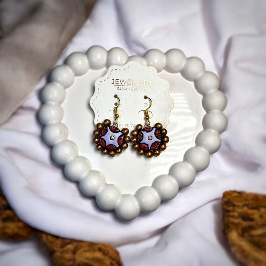 Mrritika By Astria Jewellery artisan handcrafted jewelry India purple and brown beaded earrings on white heart-shaped bead tray
