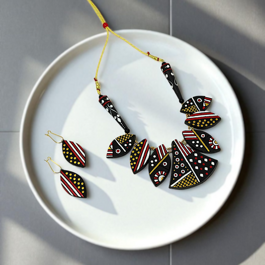 Black Trible jewelry Necklace Set with geometric patterns and matching earrings on white plate