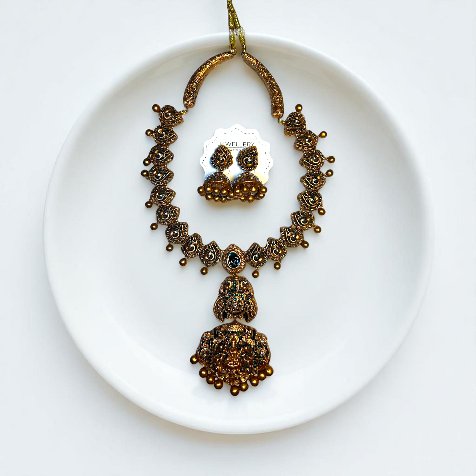 Handcrafted temple jewelry set from ASTRIA JEWELLERY featuring intricate gold-tone necklace and matching earrings 