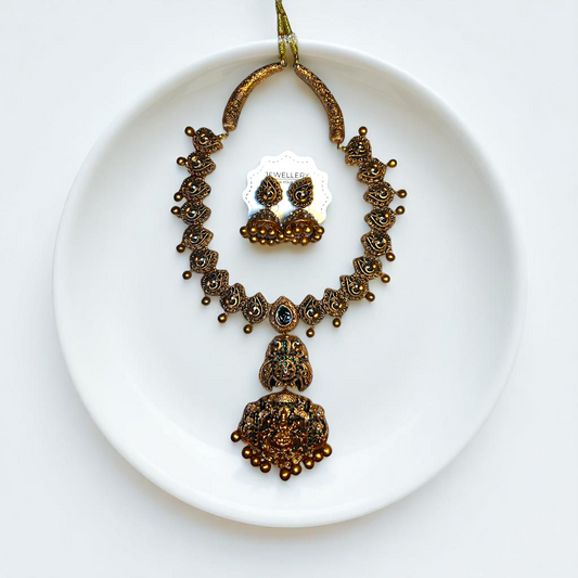 Handcrafted temple jewelry set from ASTRIA JEWELLERY featuring intricate gold-tone necklace and matching earrings 