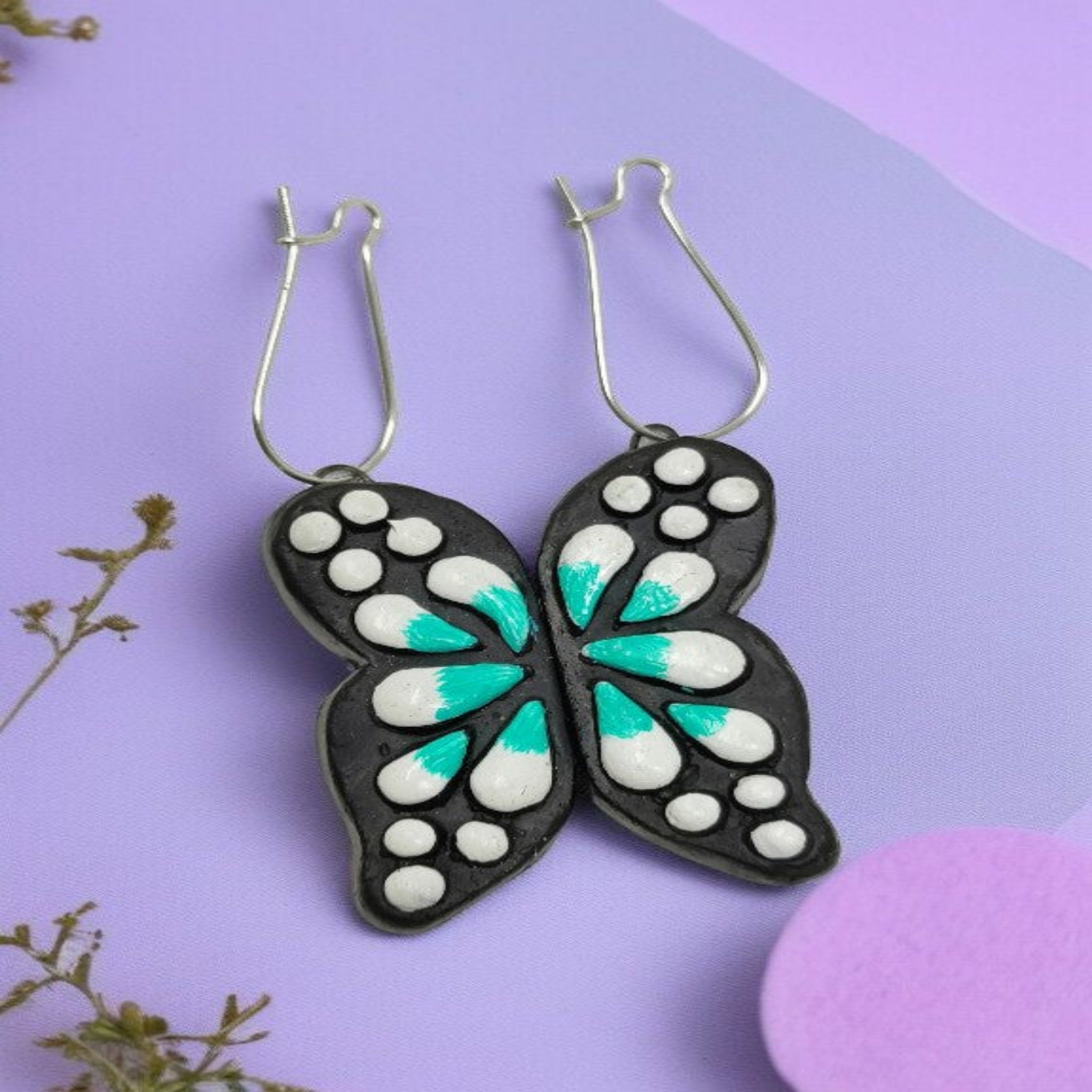 Handmade Butterfly Earrings with black base and white teal painted details on silver hooks by Mrritika By Astria Jewellery