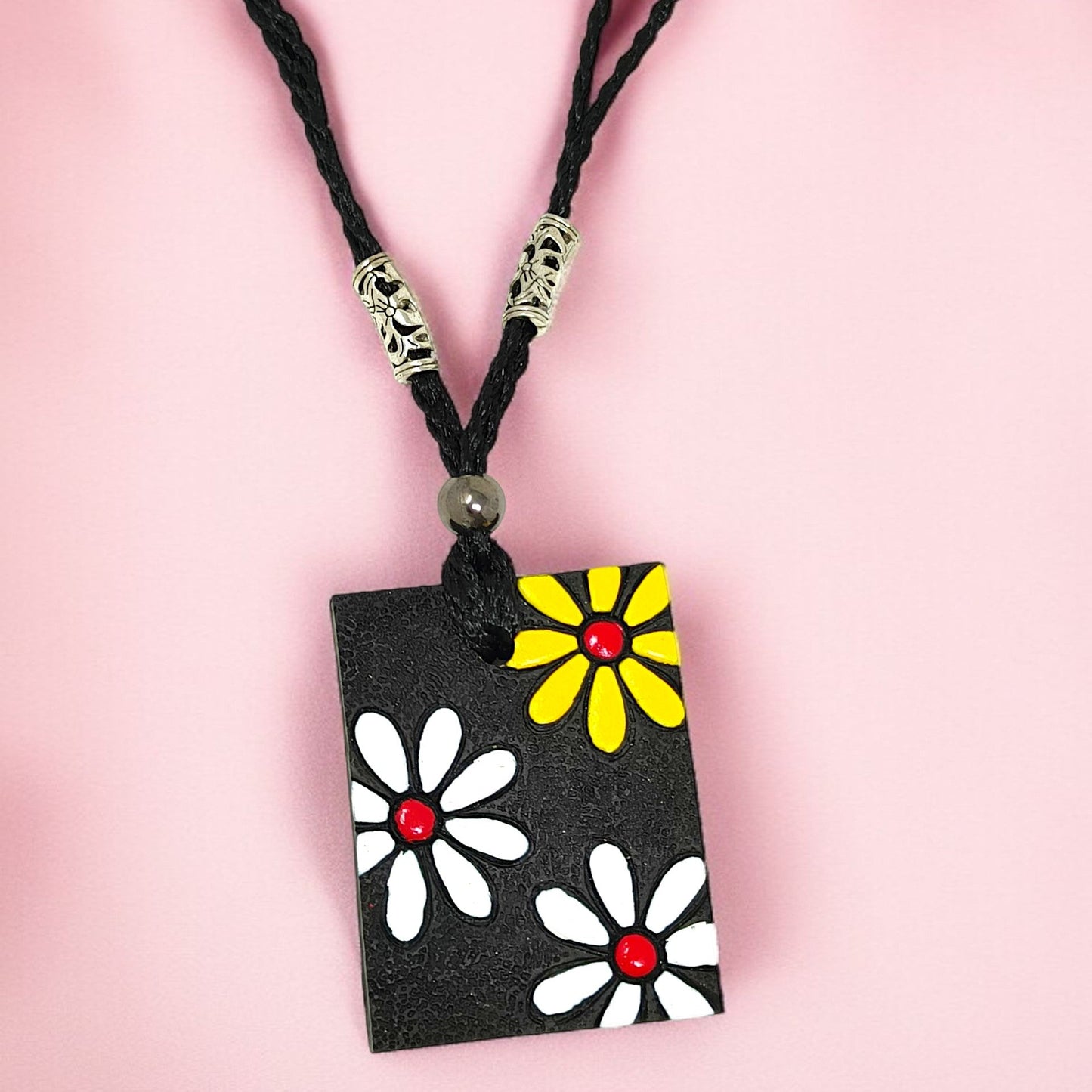Handmade floral necklace set featuring black cord and rectangular pendant with white and yellow flower designs