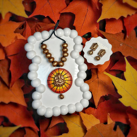 Handmade Ganesha necklace with golden beads and pendant displayed on white tray with matching earrings 
