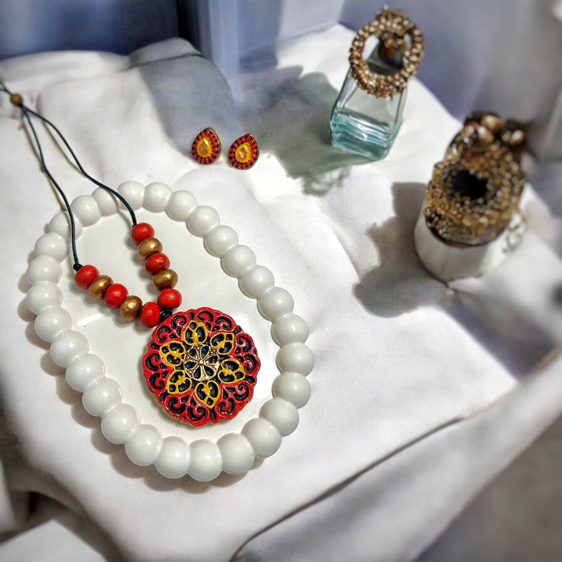 Handmade Jewelry Mandala Charm Pendent with aerring featuring red and gold intricate design on white beads necklace