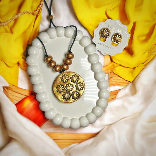 Mrritika Handmade Golden Floral Pendant with Earring displayed on white bead tray with matching floral studs