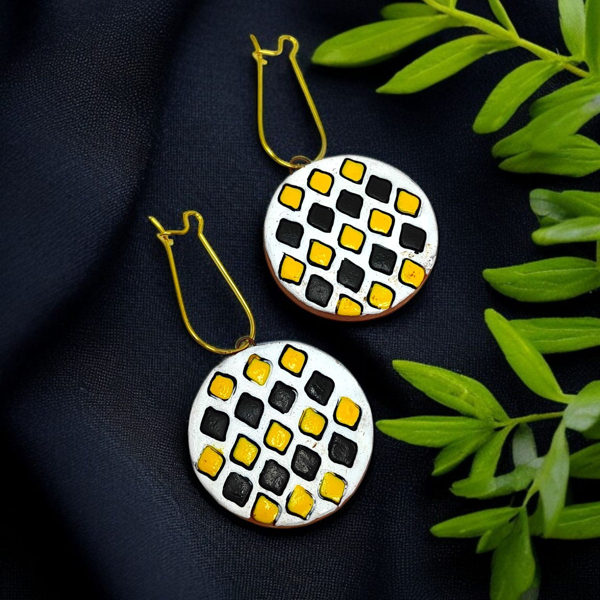 Sun Shape Minimal Handmade Terracotta Necklace with Earring featuring round black and yellow patterned earrings on black fabric