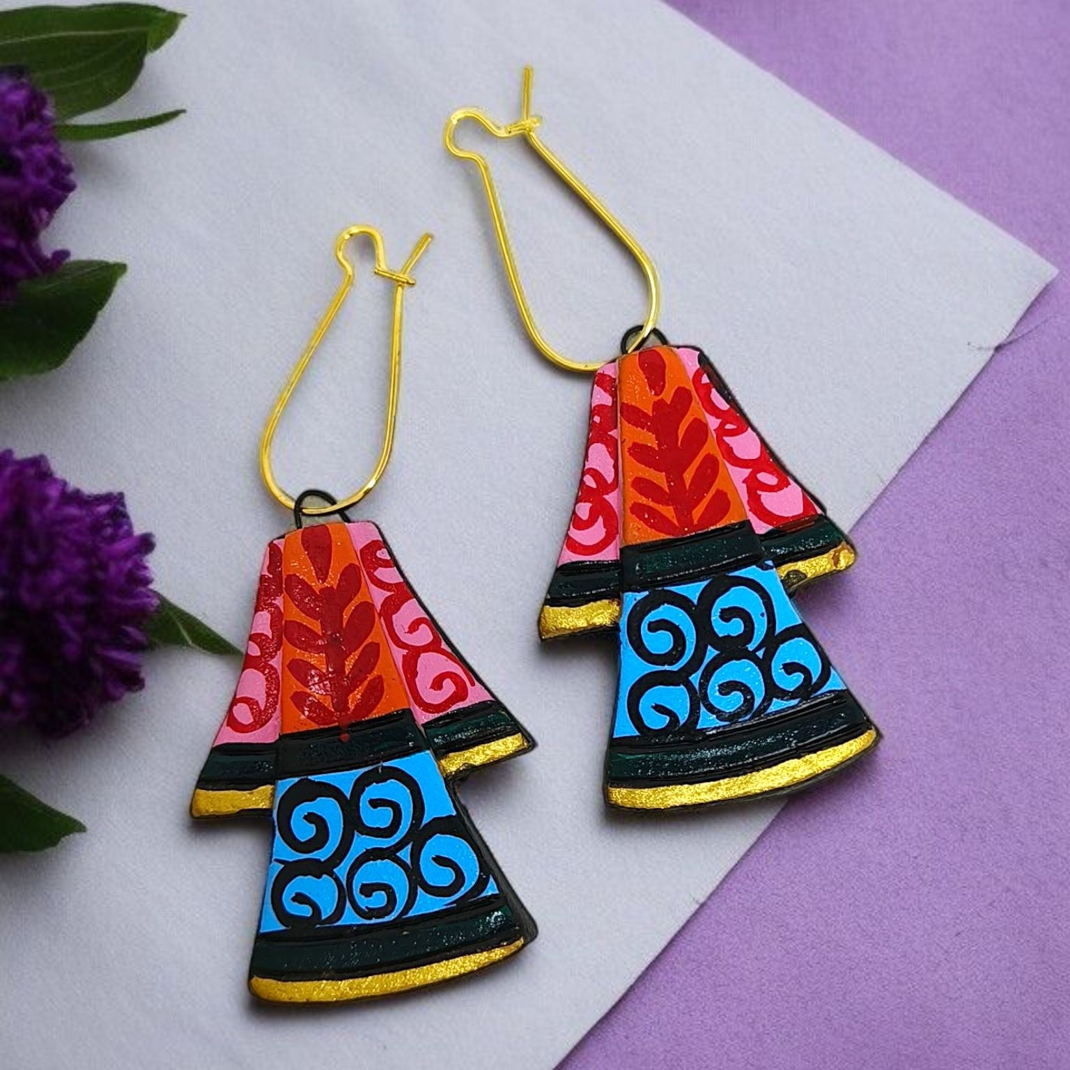 Colorful handcrafted earrings with red, pink, blue, and black patterns and gold hooks by Mrritika Handmade Jewelry 
